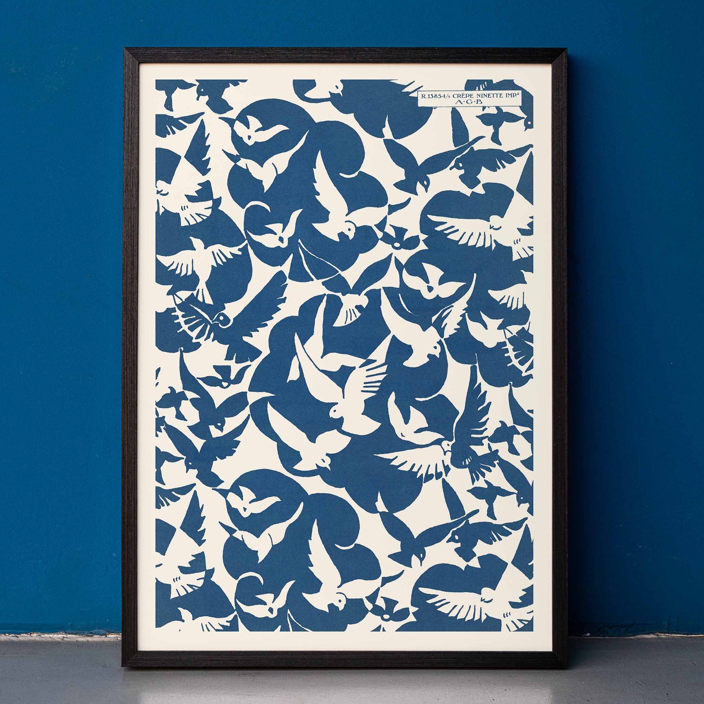 Charles Goy Lesbesse crepe poster with stylized birds in bold blue and cream minimalist design, framed and displayed in home decor