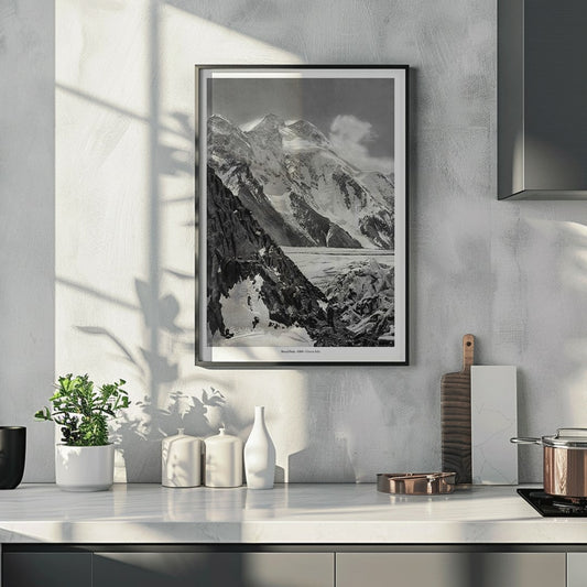 Black and white photograph and poster of Broad Peak by Vittorio Sella showing snow covered mountains and mountaineers climbing amidst rocky terrain and glacier, framed and displayed in home decor