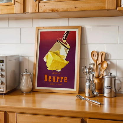 Vintage butter advertisement art by Donald Brun featuring a spatula and bold French text, framed and displayed in home decor