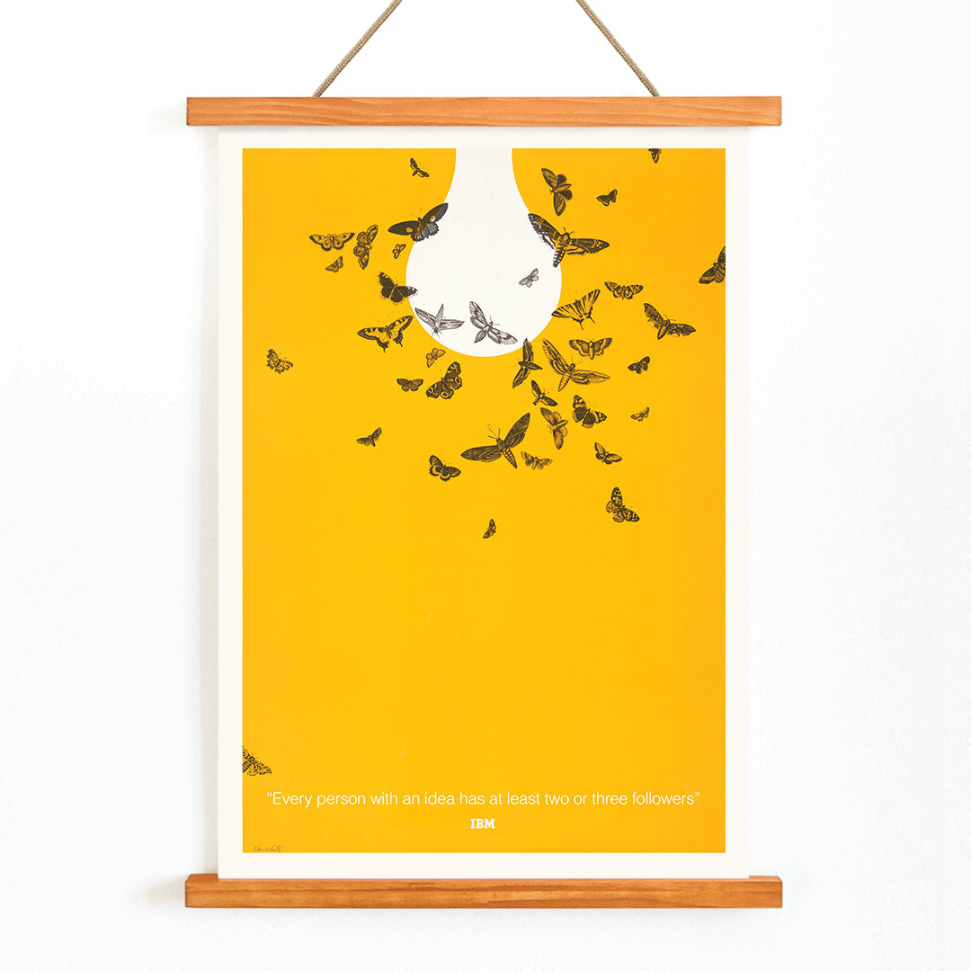 Ken White artwork Every person with an idea has at least two or three followers featuring butterflies attracted to a light bulb poster, with wooden magnetic frame on white background