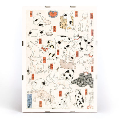 Playful and resting cats in traditional Japanese ukiyo-e art by Utagawa Kuniyoshi featuring multiple cats in various poses with Japanese elements, framed and displayed in modern living room decor