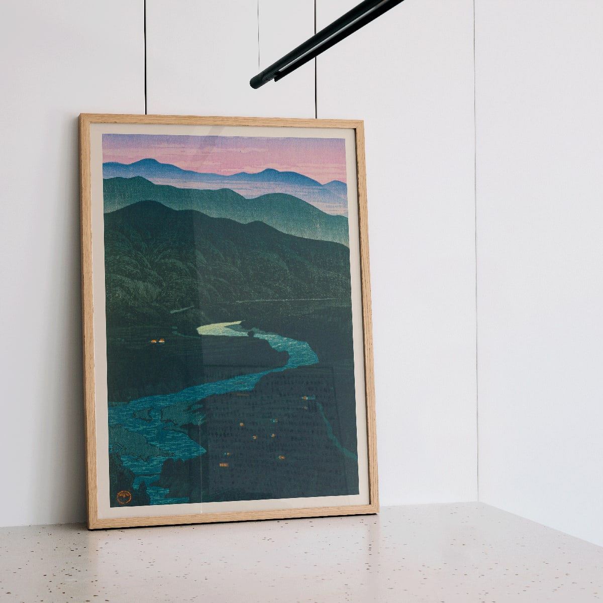 Ecchu Umidani Pass by Kawase Hasui landscape artwork showing mountains and a winding river at dawn and dusk, framed and displayed in modern living room decor