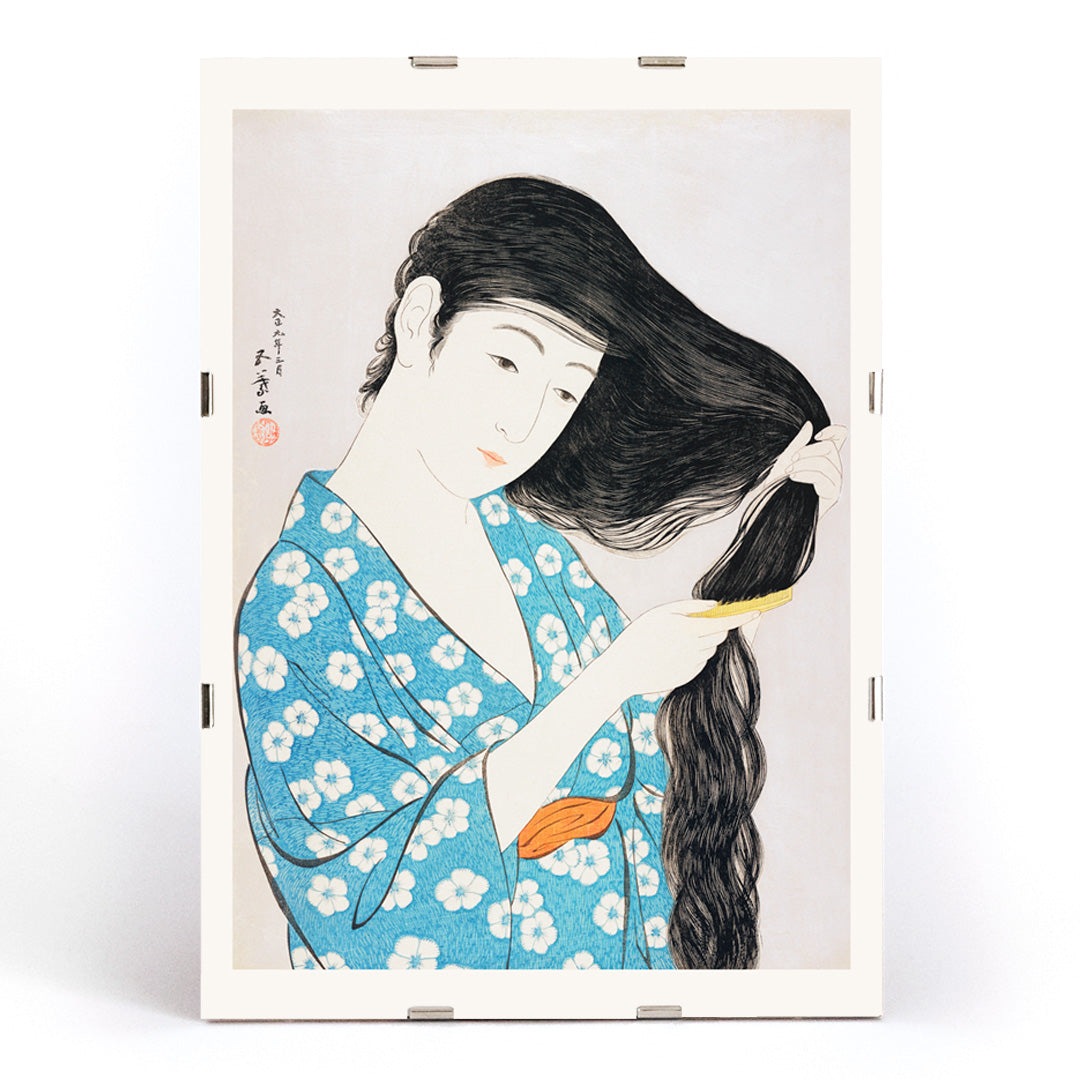 Woman in blue floral kimono combing her long hair artwork Woman Combing Her Hair by Goyo Hashiguchi Japanese art poster, framed and displayed in modern living room decor
