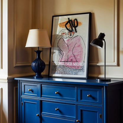 Secret Ahrenberg Collection Exhibition poster by Le Corbusier featuring abstract art with bold lines and vivid colors, framed and displayed in modern living room decor