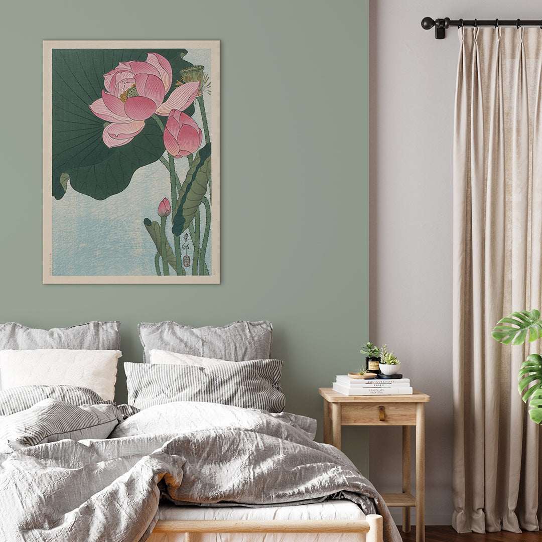 Pink lotus flowers and green leaves in Japanese woodblock print poster by Ohara Koson with light blue background, framed and displayed in home decor