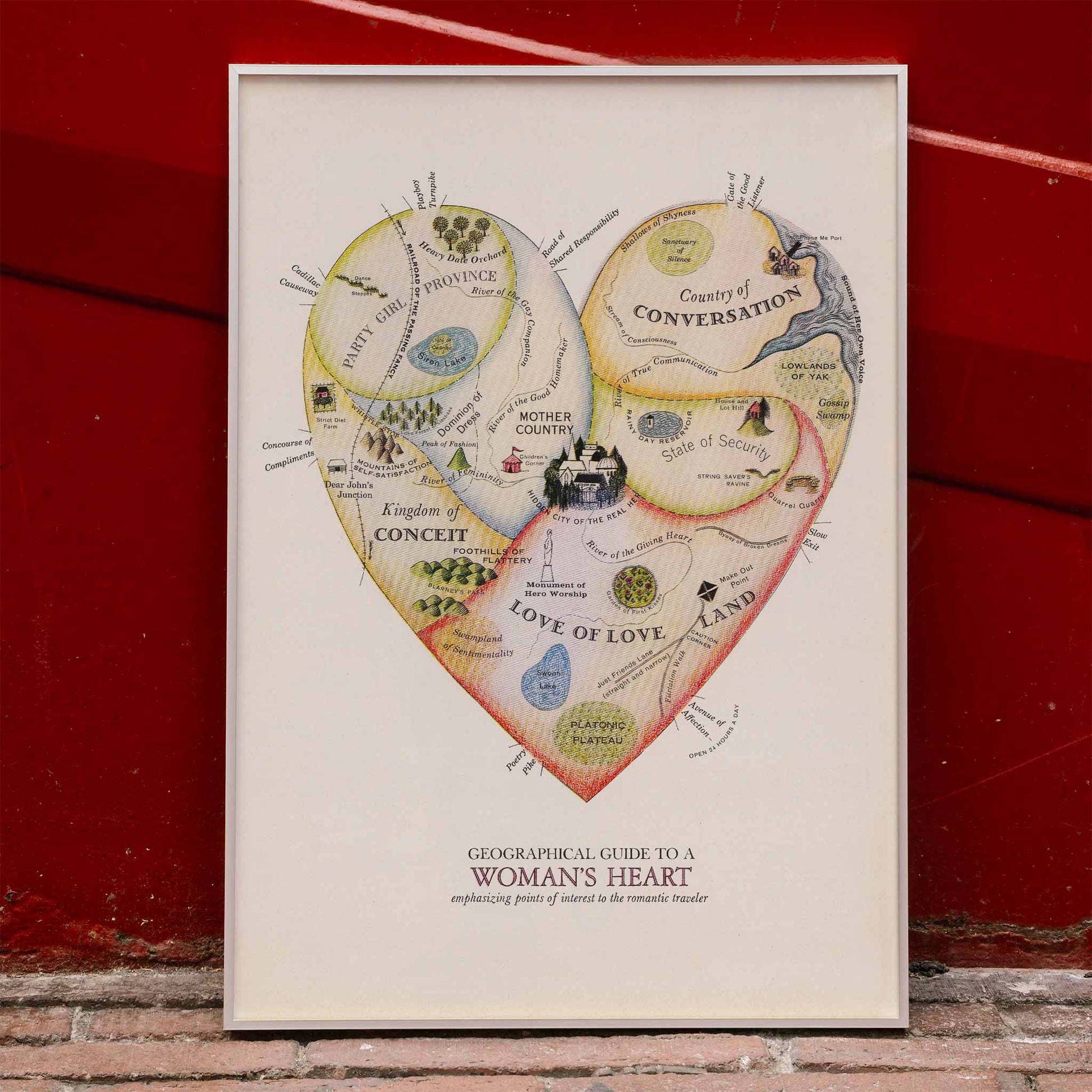Heart shaped map illustration and poster Geographical Guide to a Womans Heart by Jo Lowery whimsical map of emotions in the shape of a heart, framed and displayed in home decor