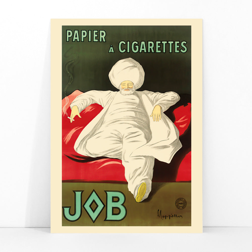 Cigarette Rolling Paper Job poster by Leonetto Cappiello showing a relaxed man in white robes and turban reclining with a cigarette on a red couch, framed and displayed in modern living room decor