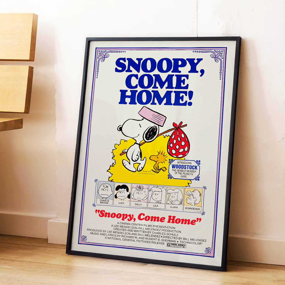 Snoopy Come Home movie poster by Charles Schulz featuring Snoopy Woodstock Lucy and Charlie Brown in colorful Peanuts illustration, framed and displayed in home decor
