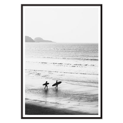 Black and white poster of surfers walking along the beach Surfers walking on the beach artwork, with black aluminium frame on white background