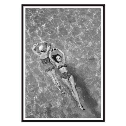 Fashion models in vintage bathing suits floating in a swimming pool artwork by Toni Frissell, with black aluminium frame on white background