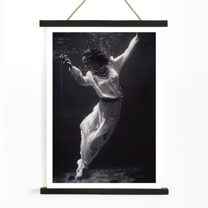 Black and white artwork of a fashion model floating underwater in dolphin tank Marineland Florida by Toni Frissell, with wooden magnetic frame on white background