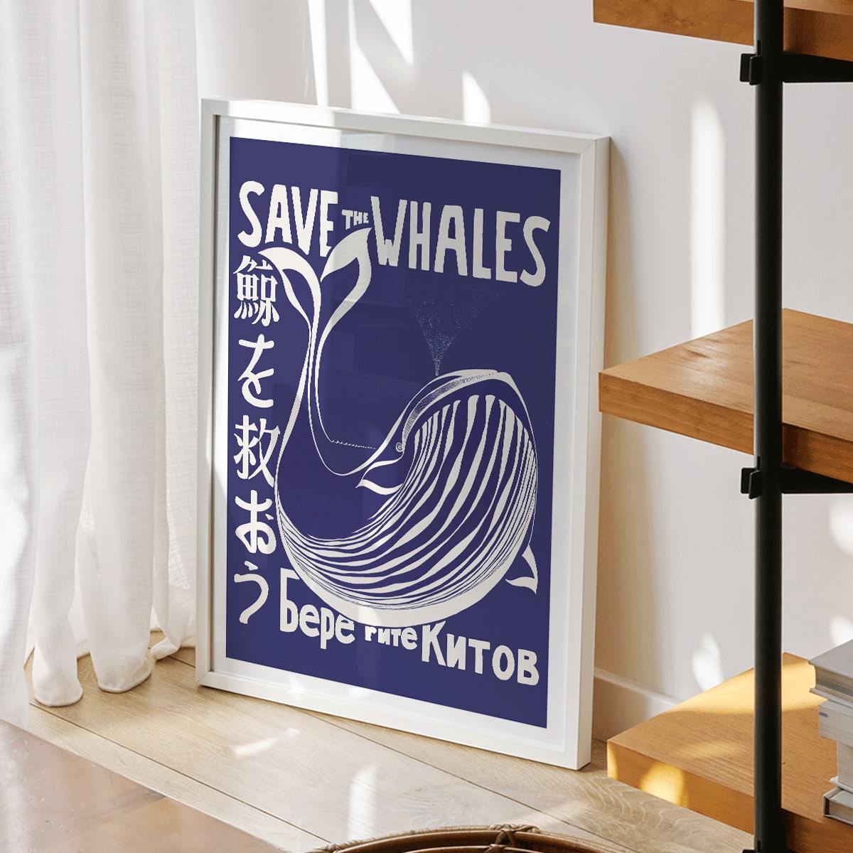 Save the Whales poster by Lawrence Vint featuring a stylized white whale and multilingual save the whales message on blue background, framed and displayed in modern living room decor