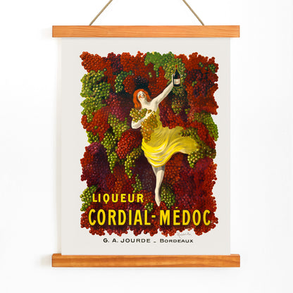 Liquor Cordial-Médoc poster by Leonetto Cappiello showing a woman in a yellow dress surrounded by colorful grapes holding a bottle, with wooden magnetic frame on white background